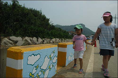 봉하마을길 연석에 그려진 추모벽화를 보며 걸어가고 있는 어린이들.