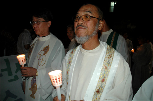 6일 저녁 마산에서 열린 시국미사에 참석한 문규현 신부가 촛불을 들고 거리행진하고 있다.