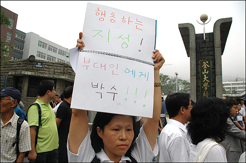 부산대 측이 노무현 추모공연을 불허하자 한 시민이 부산대 정문 앞에서 항의피켓을 들고 서 있다.