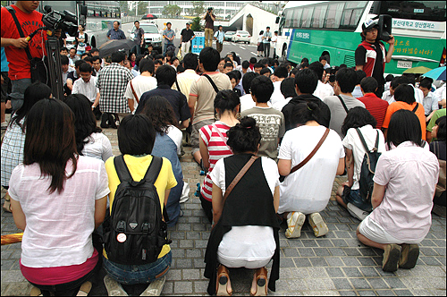 지난 8일 부산대 교직원들이 노무현 추모공연에 반대하며 정문에 앉아 있자 학생들이 무릎을 꿇고 20여분간 앉아 정문을 열어 줄 것을 호소하고 있다.