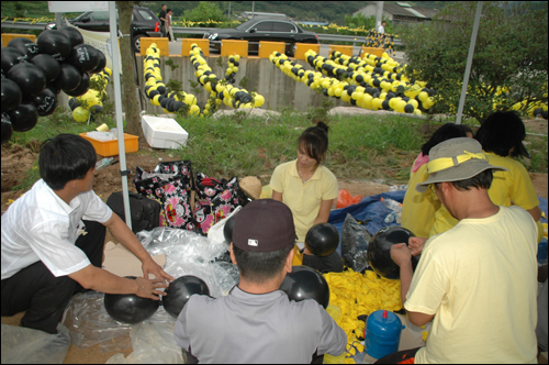 자원봉사자들이 노무현 전 대통령 묘역 주변에 노란색과 검정색 고무풍선을 매다는 작업을 벌이고 있다.