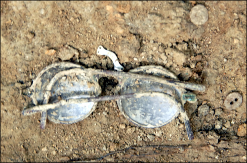 희생자의 것으로 추정되는 구덩이 속에서 발굴된 안경