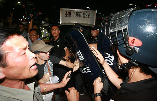 10일 저녁 서울 덕수궁 대한문 앞에서 열린 고 노무현 전 대통령 49재 추모행사에 참석한 시민들이 추모공연 무대차량을 막는 경찰과 실랑이를 벌이고 있다.