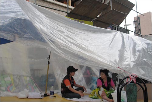 비가 내린 12일 오후, 용산 남일당 건물 앞 농성천막에서 철거민들이 이야기를 나누고 있다.