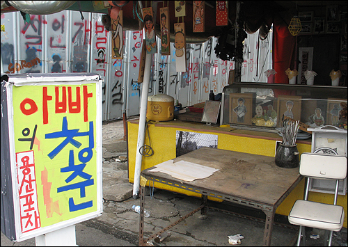 빈 가게에 차려진 '아빠의 청춘 용산포차'. 철거된 가게들의 그림과 주인들이 메뉴판에 그려져있다.