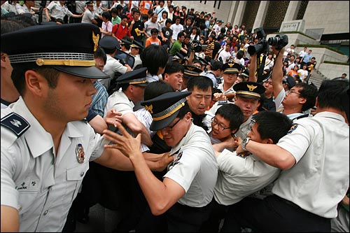 '기자회견이 끝났다'는 사회자의 말이 끝나기 무섭게 경찰들이 뛰어들어 이원기 의장을 끌어내고 있다.