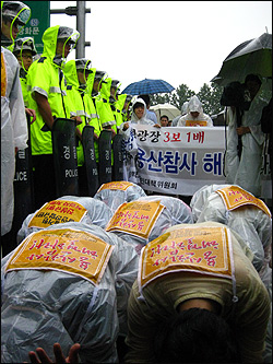 17일 오후 서울시청 앞 광장에서 수사기록 공개와 용산참사 해결을 촉구하며 용산 유가족과 민주노동당 이수호 최고위원, 이정희 의원이 삼보일배를 진행하고 있다. 경찰은 현수막 뒤에 선 반절을 하며 오는 이들을 가로막았다.  

