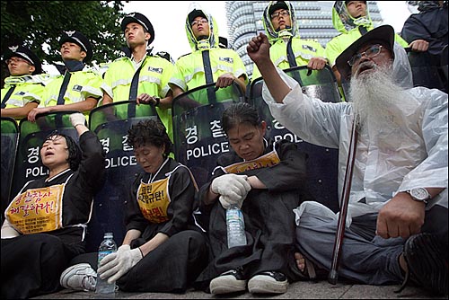 지난 7월 18일 오후 서울 청계광장 앞에서 이명박정권 용산철거민살인진압 범국민대책위원회원들과 유가족들이 용산참사 문제에 대해 정부의 책임 있는 해결을 촉구하며 청와대로 향해 삼보일배를 진행하자 경찰들이 막아서고 있다. 