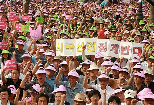 지난 7월19일 오후 서울역광장에서 열린 '민주회복민생살리기 제2차 범국민대회'에서 참석자들이 '시국선언 징계반대' 피켓을 들고 구호를 외치고 있다.