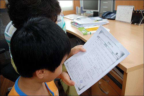 공부방 선생님이 아이의 과학실험보고서를 봐주고 있다. 마장동 방과후 공부방에서는 과학실험, 난타교실 등 다양한 체험 학습이 이루어진다. 