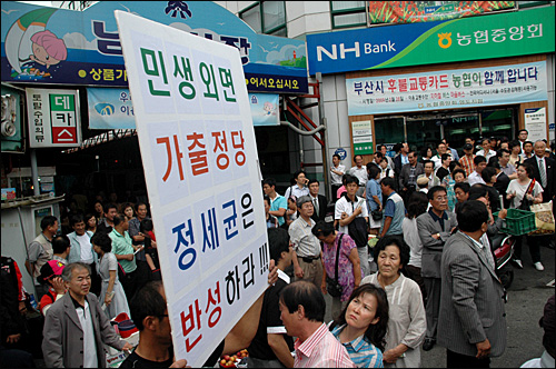  민주당이 31일 오후 부산 영도 남항시장 입구에서 연설회를 열기 전 한 남성이 정세균 민주당 대표를 비난하는 종이피켓을 들고 서있다. 