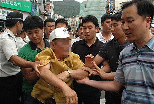  민주당이 31일 오후 부산 영도 남항시장 입구에서 열려는 연설회를 방해하던 한 노인이 경찰에 제지당하고 있다.