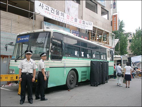 남일당 건물 옆에 서 있는 경찰 버스.