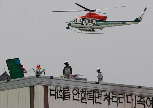 지난 2009년 8월 3일 쌍용자동차 투쟁 당시 도장 공장을 점거 중인 노조원들 위로 경찰헬기가 지나고 있다. 