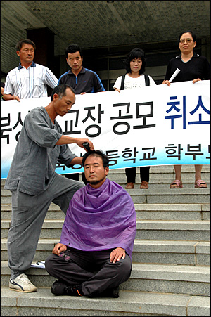  서원 거창북상초등학교 운영위원장은 '교장 공모 취소 철회'를 요구하며 3일 경남도교육청 현관에서 삭발했다.