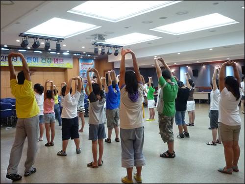 '2009 어린이 건강캠프'에 참가한 초등학생들이 선생님과 함께 스트레칭으로 몸을 풀고 있다.