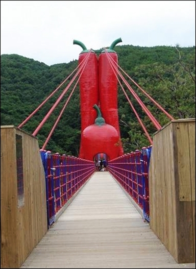 세 개의 붉은 고추 모양 탑이 인상적인  출렁다리 입구 풍경