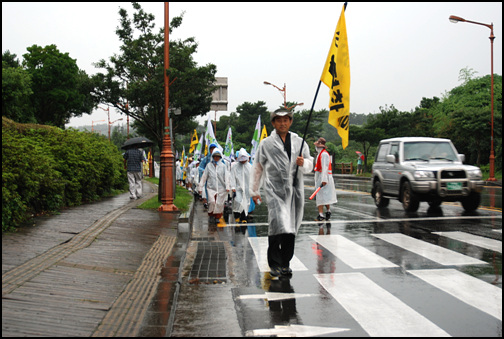 순례대열 맨 앞에서 양홍찬 위원장이 깃발을 들고 걷고 있다.