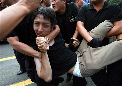'광복 64돌 8·15 시국대회'가 열릴 예정인 마로니에 공원앞에서 한 참가자가 경찰에 강제연행당하고 있다.