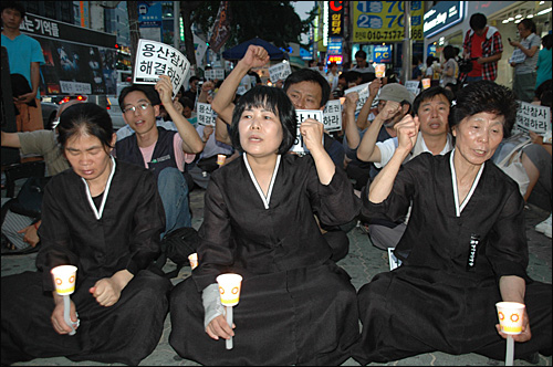 '용산참사 문제 해결을 위한 전국 순회 촛불문화제'가 2009년 8월 17일 저녁 부산 서면에서 열렸다. 사진은 용산 참사 희생자 부인들이 상복을 입고 촛불을 들고 참석한 모습.
