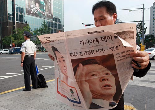 18일 오후 서울 덕수궁 대한문 앞에서 시민들이 고 김대중 전 대통령 서거 관련 뉴스를 알리는 호외를 읽고 있다.