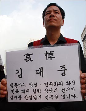 18일 오후 서울 덕수궁 대한문 앞에서 한 시민이 고 김대중 전 대통령 서거에 애도의 뜻을 표하며 손피켓을 들어보이고 있다.