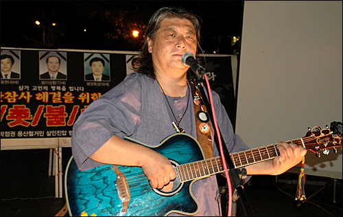 가수 우창수씨가 18일 저녁 창원에서 열린 '용사참사 해결을 위한 촛불문화제'에 참석해 노래를 부르고 있다.