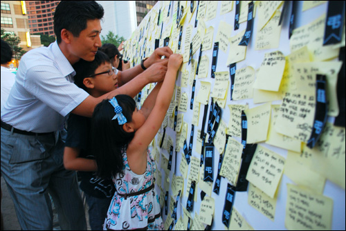 서울광장 분향소를 찾은 시민들이 '김대중 대통령 추모의 벽'에 쪽지 글을 남기고 있다.
