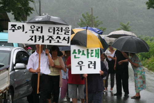  골프장 공사 중지를 위한 북면 주민 기도회 참석자들이 빗속에 행진을 하고 있다.
