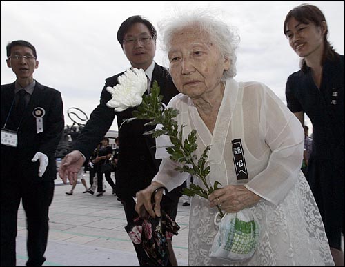 22일 오후 여의도 국회에 마련된 고 김대중 전 대통령 국장 빈소에서 한 할머니가 헌화하고 있다. 