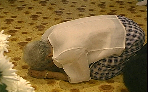 한 어르신이 대통령 영정 앞에서 큰절을 한 후 슬픔에 겨워 한참동안 엎드려 있다.