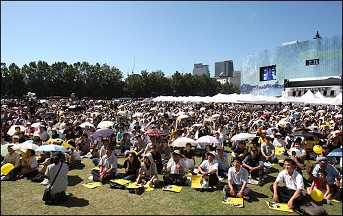  고 김대중 전 대통령 국장 영결식이 23일 오후 여의도 국회에서 진행되는 가운데, 서울시청앞 서울광장에 마련된 분향소에 많은 추모객들이 모여 앉아 영결식 생중계를 시청하고 있다.