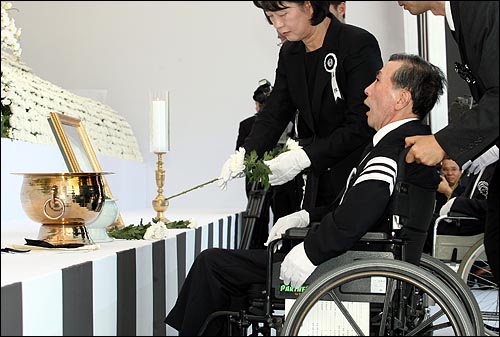  23일 오후 여의도 국회에서 엄수된 고 김대중 전 대통령 국장 영결식에서 장남 김홍일 전 의원이 부인의 도움으로 헌화하고 있다.