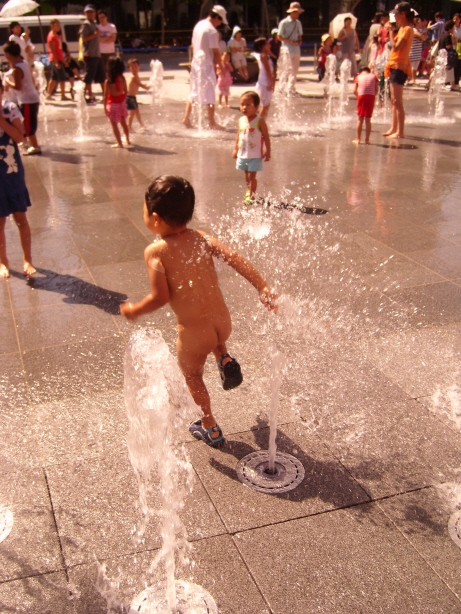 광화문광장 분수대에서 어린아이가 뛰어 놀고 있다.