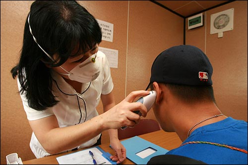 신종인플루엔자 환자가 급속하게 확산되는 가운데 2009년 8월 25일 오후 서울 용산구보건소 앞마당에 설치된 컨테이너에서 간호사가 감기증상으로 찾아온 환자의 체온을 재고 있다.(자료사진)