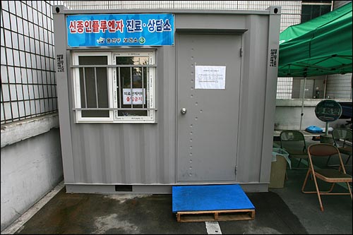 신종인플루엔자가 급속히 확산되는 가운데 25일 오후 서울 용산구보건소 주차장에 컨테이너 박스를 이용한 '신종인플루엔자 진료·상담소'와 대기자를 위한 천막 및 의자가 마련되어 있다.