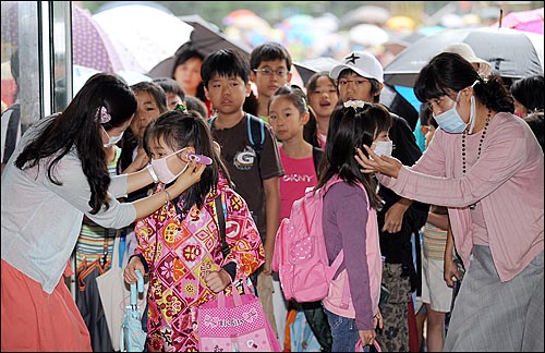 27일 오전 서울 신용산초등학교에서 등교하는 학생들이 고막 체온계로 체온을 측정 받고 있다.