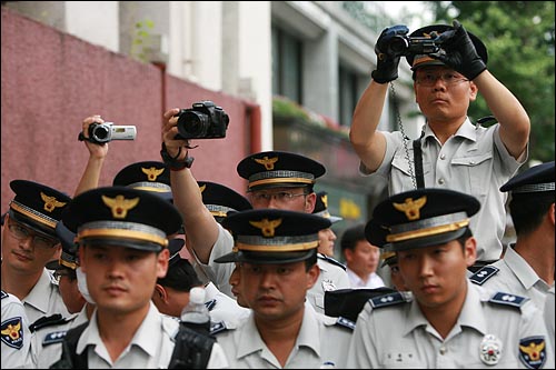 서울시의회앞 인도에서 삼보일배 행렬을 가로막고 나선 경찰들이 참가자들의 모습을 여러대의 카메라를 동원해서 채증하고 있다.