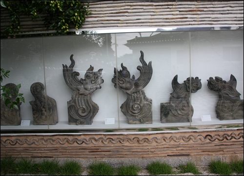 마당 한쪽 벽체전시관에 전시된 와당과 기와 유물들