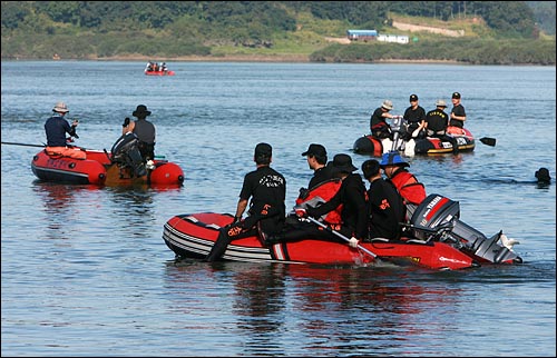 8일 오전 경기도 연천군 임진강 비룡대교 부근에서 잠수복을 입은 119구조대원들이 고무보트를 타고 지난 6일 새벽 갑자기 불어난 물에 실종된 야영객 6명중에서 발견되지 않고 있는 3명의 시신을 찾고 있다.