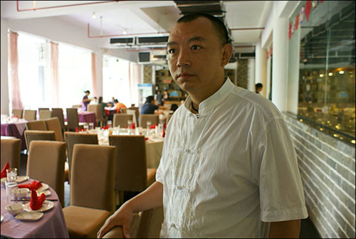 음식체험관 1층 식당을 배경으로 포즈를 취한 거우더 관장. 요리사에서 사업가로 성공하여 쓰촨요리의 세계화에 전력을 기울이고 있다.