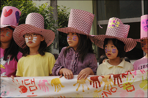 초등학생들이 '지리산댐 NO'와 자신들의 손바닥이 찍힌 펼침막을 들고 어른들의 말을 귀기울여 듣고 있다.
