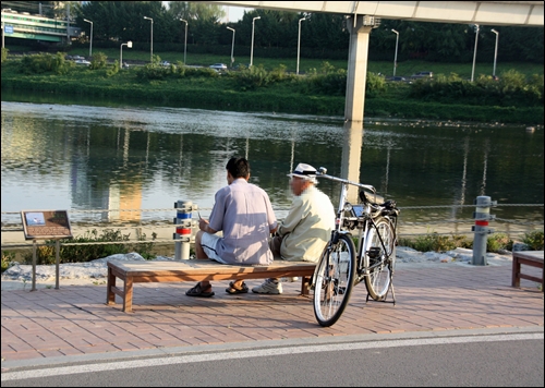  청계천 하구 쉼터 의자에 앉아 쉬고 있는 노인들