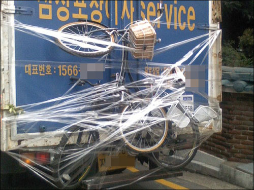 차탄풍 공모 수상작 '거미줄에 걸린 자전거'. 이삿짐 나르는 차량 뒤에 꽁꽁 묶여있는 자전거가 마치 거미줄에 걸려있는 듯 하다. 
