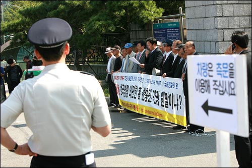 고 김대중 전 대통령 묘지 이장을 요구하는 보수단체 회원들의 기자회견을 경찰들이 지켜보고 있다.