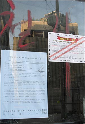 삼호복집이 있는 근경빌딩 입구 유리문에 붙은 경고장 두 개. 건물에는 철거라는 붉은 글씨가 여기저기 적혀있었다.