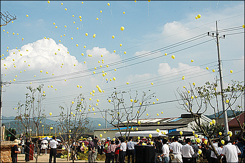24일 봉하마을에서 열린 고 노무현 대통령 생가 복원식에 참석한 시민들이 노란색 고무풍선을 하늘로 날려 보내고 있다.