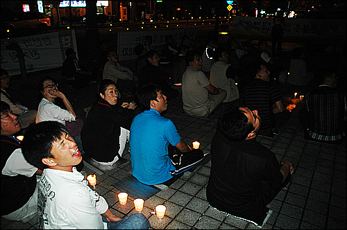  24일 저녁 창원 소재 한국전력공사 경남본부 앞에서 열린 '전기원 노동자 장기투쟁 승리와 경남지역 투쟁사업장 연대 촛불문화제' 때 참석자들이 한전 건물을 향해 고함을 지르고 있다.