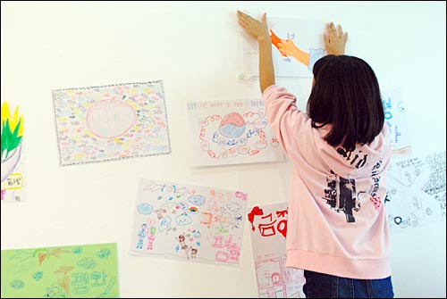 평화예술제의 한 프로그램인 '평화그림 함께 그려요'에 참여한 학생이 자신이 그린 그림을 벽에 붙이고 있다.