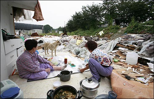 강제철거로 집이 부서져 버린 주민들은 이웃집에 얹혀 살고 있다. 가끔 이렇게 밖에 나와 밥을 해먹고 지낸다.